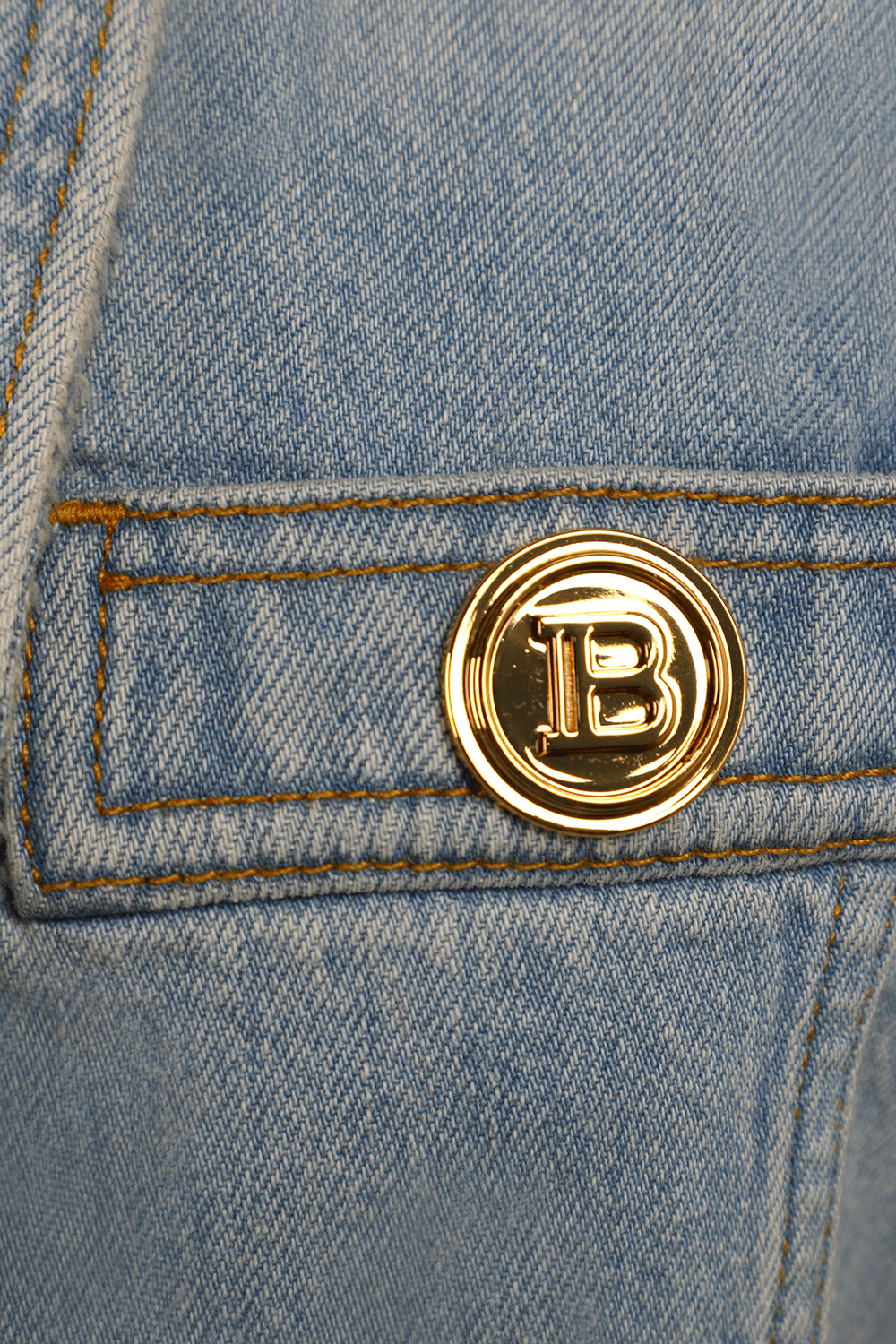 תמונה אחורית של ז'קט ג'ינס בהיר מחויט עם כפתורי זהב