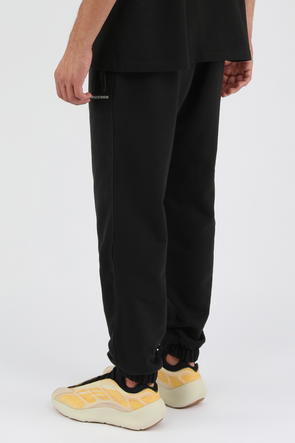 תמונת דוגמן אחורית של פארל וויליאמס X אדידס מכנסי טרנינג שחורים