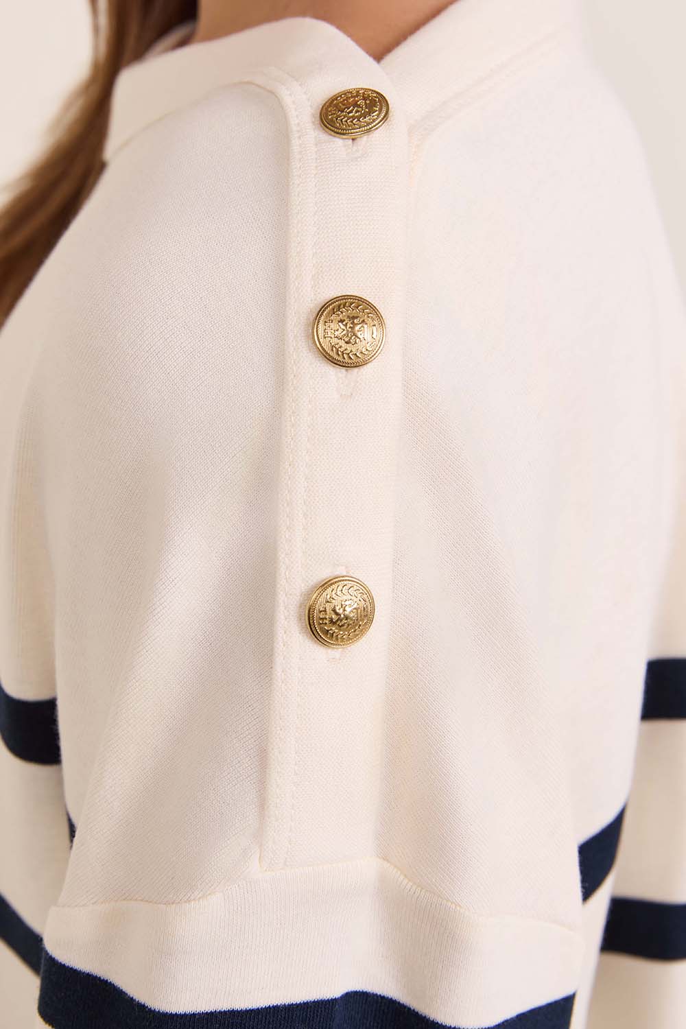 תמונת תקריב דוגמן של חולצת טי עם כפתורים זהובים