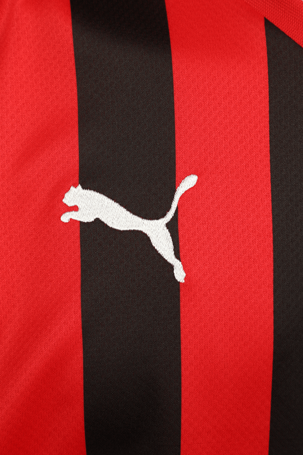 תמונת תקריב של חולצת כדורגל מילאן בית בגווני אדום ושחור