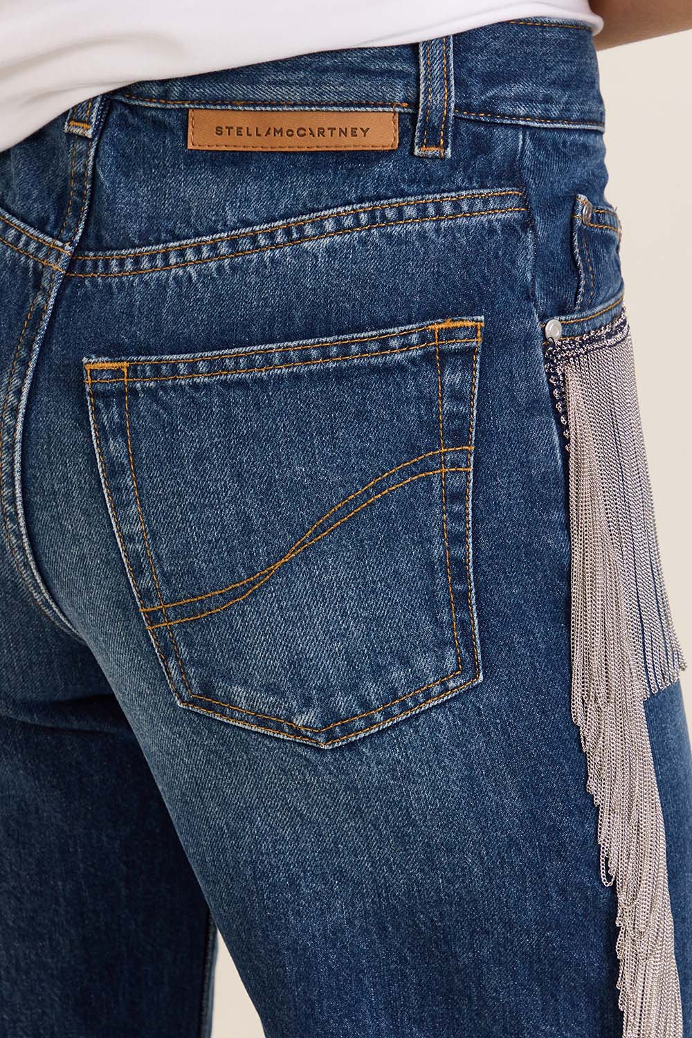 תמונת תקריב דוגמן של מכנסי ג'ינס רחבים עם פרנזים מטאלים