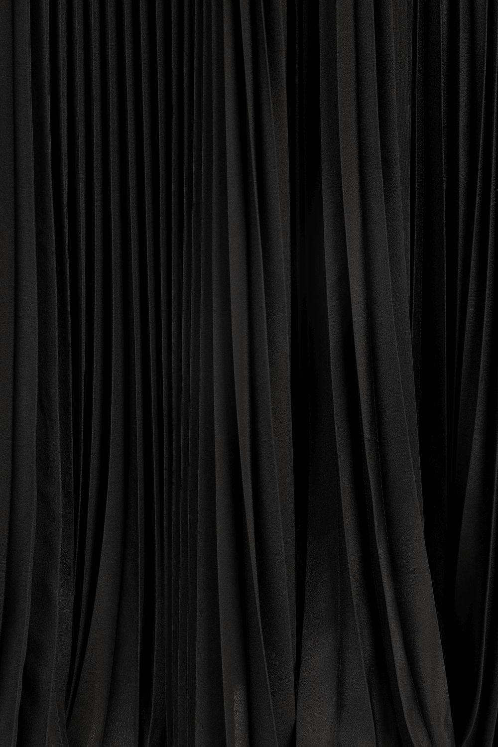 תמונה אחורית של חצאית מידי שחורה עם קפלי פליסה