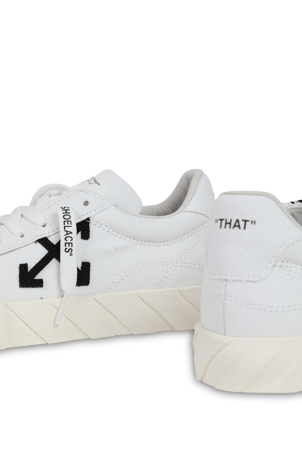 תמונת תקריב של נעלי סניקרס קנבס אקו עם כיתוב ממותג בגוון לבן ושחור