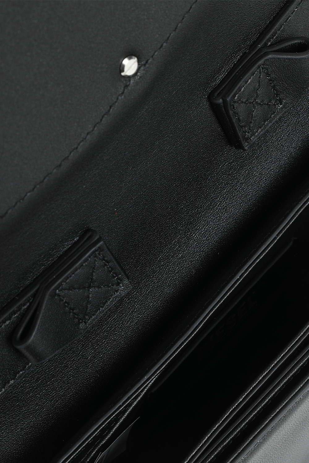 תמונת פנים של תיק כתף מעור שחור עם אלמנט לוגו מטאלי בחזית