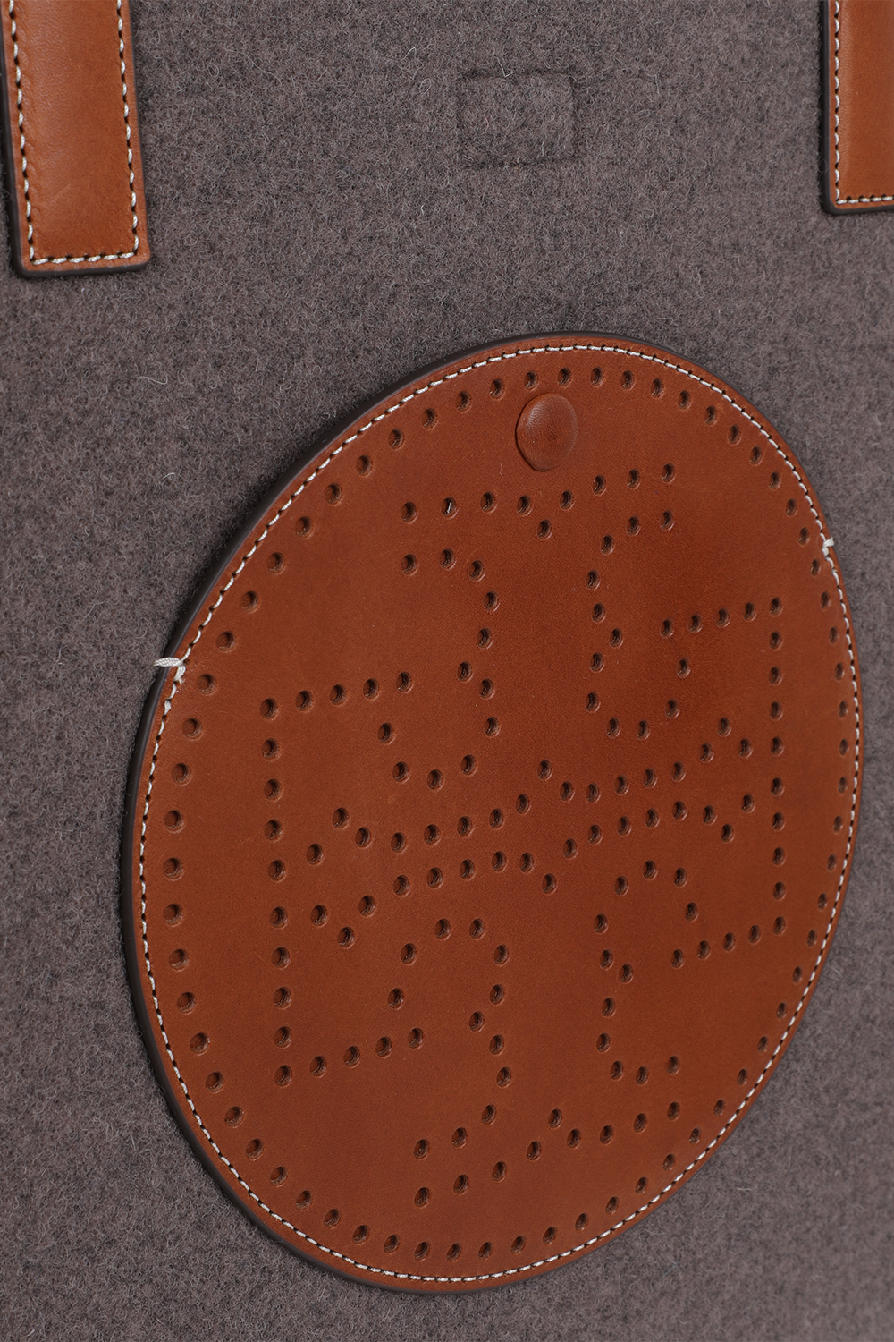 תמונת תקריב של תיק נשיאה מצמר עם רקמה מונוגרמית