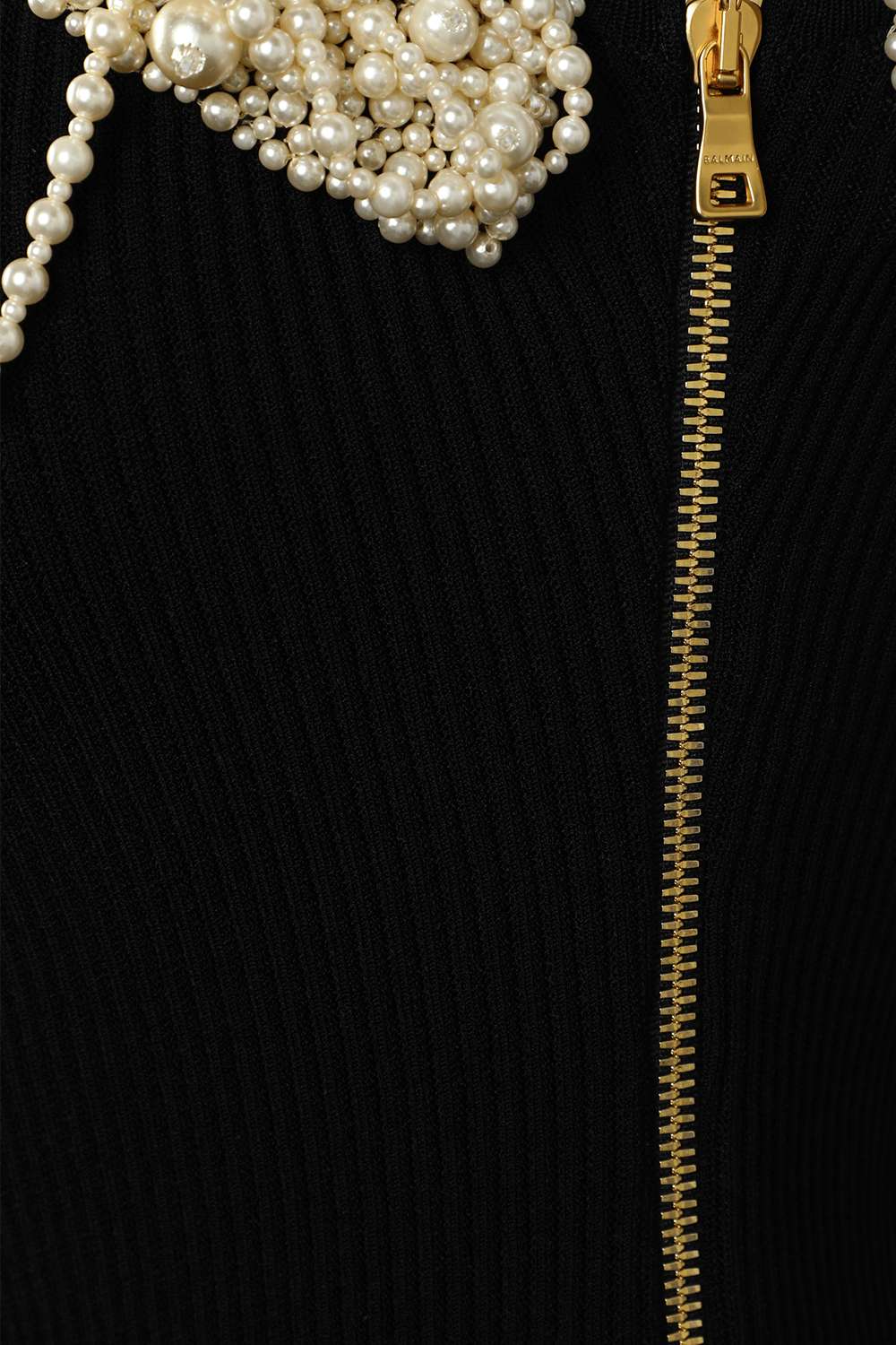 תמונת תקריב של שמלת מיני ריב א-סימטרית עם פנינים