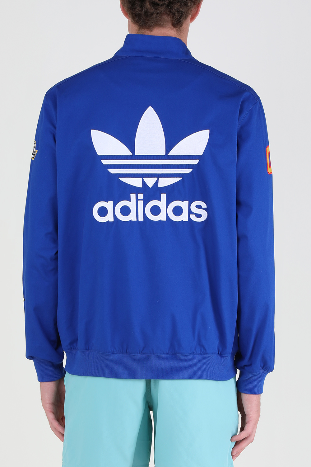 תמונת דוגמן אחורית של אדידס X שון ווטרספון והוט הילס מעיל מרוצים עם פאצ'ים