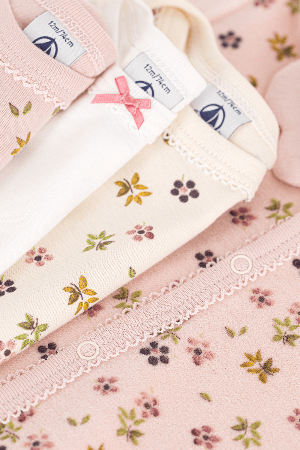 תמונת תקריב של מארז אוברול פיג'מה ושלושה בגדי גוף - גילאי 3-24 חודשים